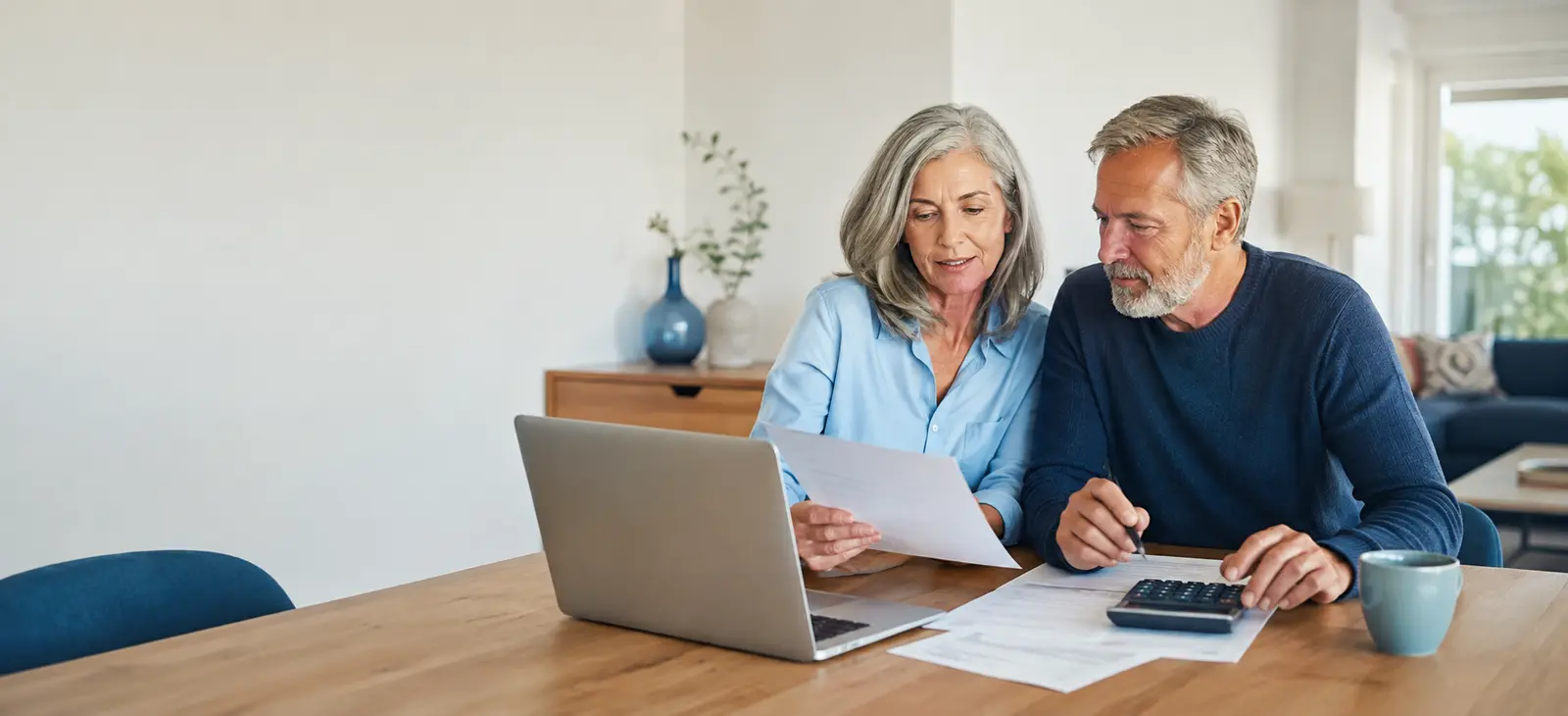 Pareja preparando su jubilación con documentos y calculadora